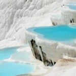 Turquoise terraced hot springs cascading over white travertine at Pamukkale, Turkey.