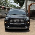 Front view of a black Toyota SUV showing a prominent grille and headlights in a parking area.