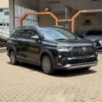 Black Toyota SUV parked in a car wash area with a modern front grille and glossy finish.