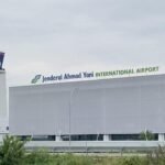 Jenderal Ahmad Yani International Airport terminal with control tower and signage on the facade in Semarang, Indonesia.