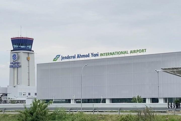 Jenderal Ahmad Yani International Airport terminal with control tower and signage on the facade in Semarang, Indonesia.