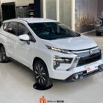 White modern SUV on a showroom floor with Berkah Jaya Trans branding on the logo mat nearby, sleek chrome grille and angled headlights visible.