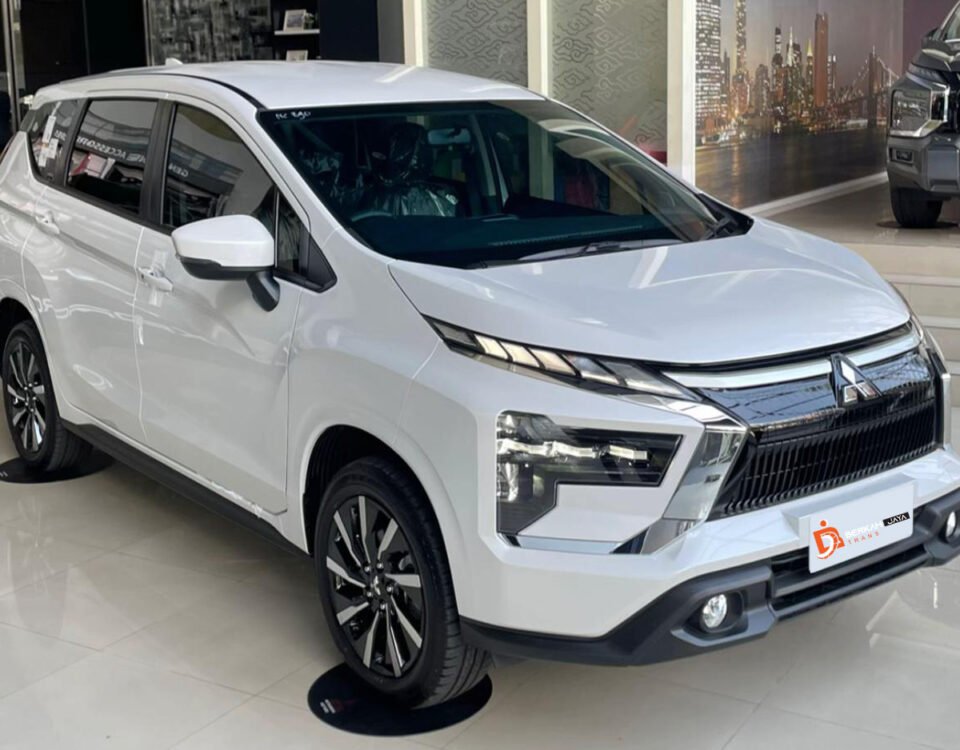 White modern SUV on a showroom floor with Berkah Jaya Trans branding on the logo mat nearby, sleek chrome grille and angled headlights visible.