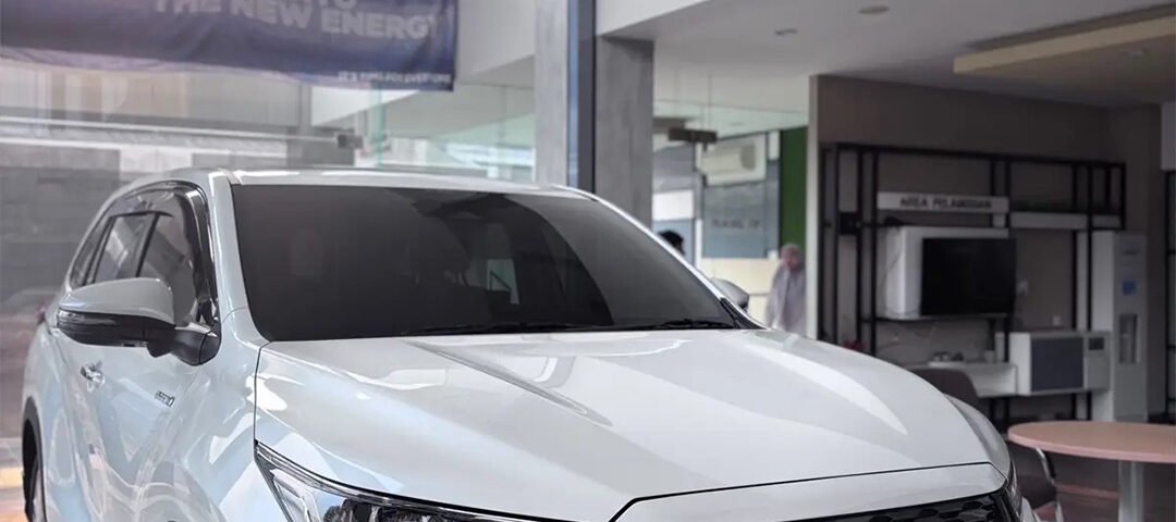 White Toyota SUV on display in a modern showroom, featuring a bold black grille and the orange DYAN TRANSPORT logo on the bumper.