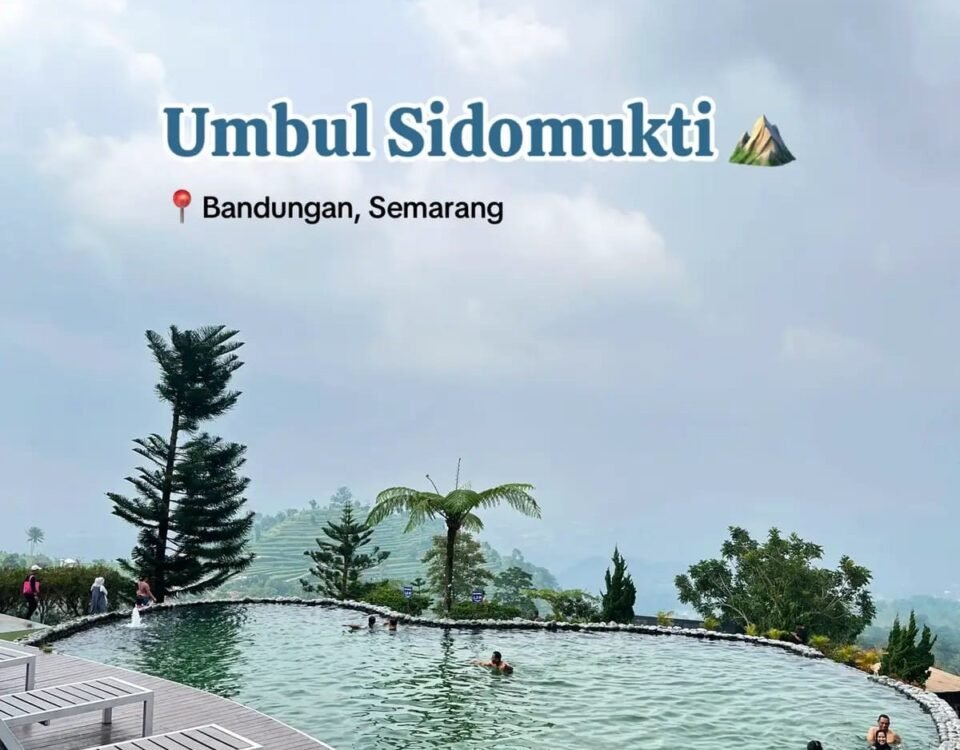 Pool at Umbul Sidomukti with wooden deck, people swimming and lounging, mountain backdrop and palm trees