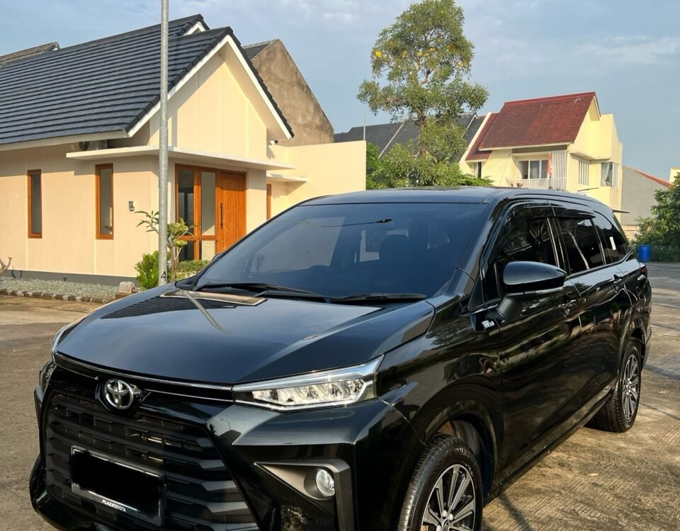 snaptik_7369070534291623174_2_v2 - Dyantransport Black Toyota SUV parked in a suburban driveway with beige houses and a tree in the background, under a blue sky.