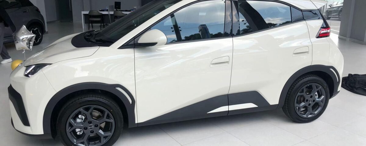 White crossover SUV on a showroom floor, shown in a side-front profile with black trim and dark alloy wheels.