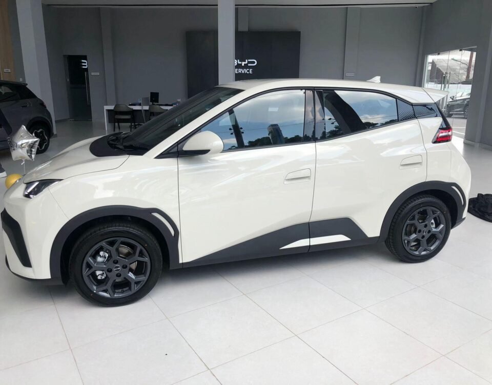 White crossover SUV on a showroom floor, shown in a side-front profile with black trim and dark alloy wheels.