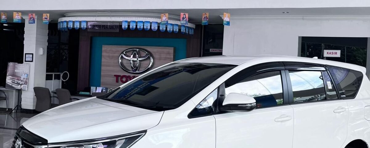 snaptik_7609535208643202312_7_v2 (2) - Dyantransport White Toyota SUV on a glossy showroom floor with promotional banners overhead in a dealership.
