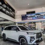 White Toyota Veloz SUV on a showroom floor with glossy black wheels and a bold front grille.