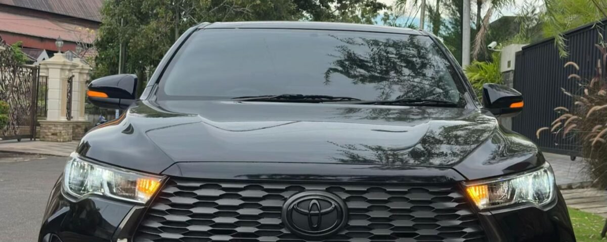 Front view of a black Toyota SUV parked on a residential street with trees and power lines overhead.