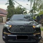 Front view of a black Toyota SUV parked on a residential street with trees and power lines overhead.