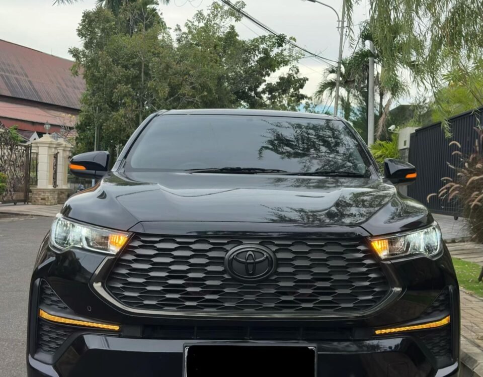 Front view of a black Toyota SUV parked on a residential street with trees and power lines overhead.