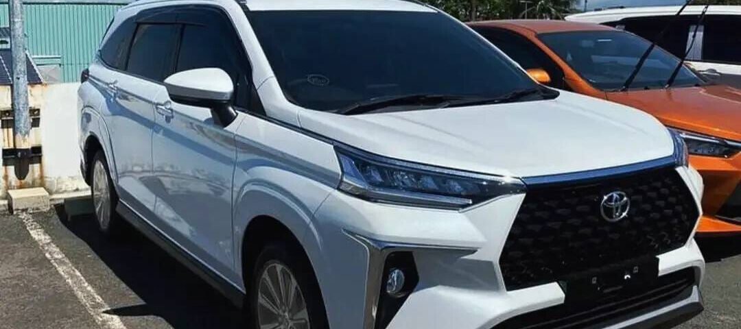 White Toyota SUV parked in a lot on a sunny day, front view highlighting the bold black grille and angular front fascia.