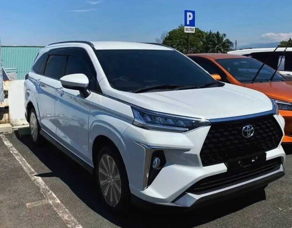 White Toyota SUV parked in a lot on a sunny day, front view highlighting the bold black grille and angular front fascia.
