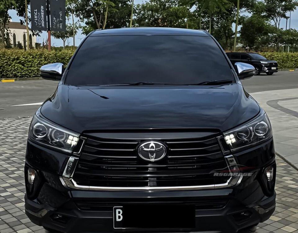 Front view of a black Toyota SUV parked on a tiled plaza, chrome grille and emblem centered on the grille.