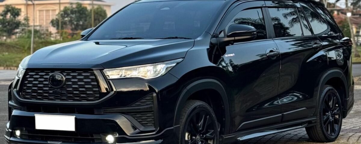Black SUV parked on a paved street, front-three-quarter view showing a glossy finish and bold grille.