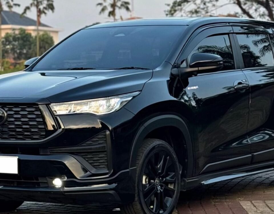 Black SUV parked on a paved street, front-three-quarter view showing a glossy finish and bold grille.
