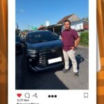 Pria berdiri di samping mobil SUV hitam di jalan, terkait posting CV Berkah Dyantransport.