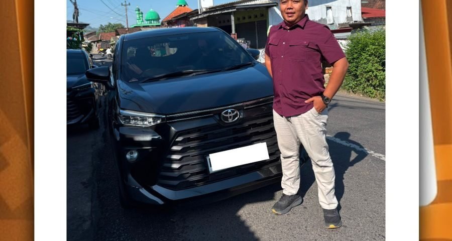 Pria berdiri di samping mobil SUV hitam di jalan, terkait posting CV Berkah Dyantransport.