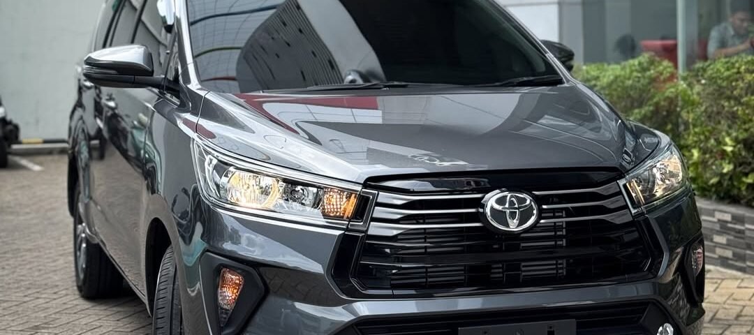 Gray Toyota SUV parked diagonally in front of a modern glass building with a red wall in the background