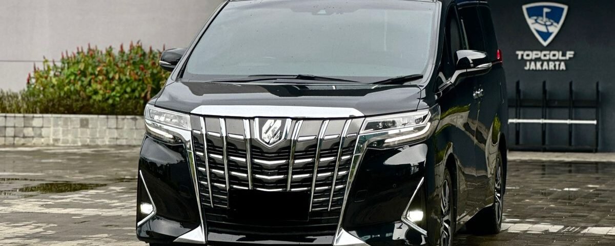 Black luxury minivan parked in front of the Topgolf Jakarta entrance/line of the building.