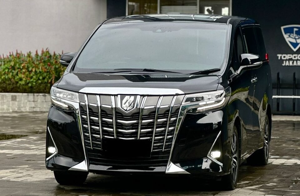 Black luxury minivan parked in front of the Topgolf Jakarta entrance/line of the building.