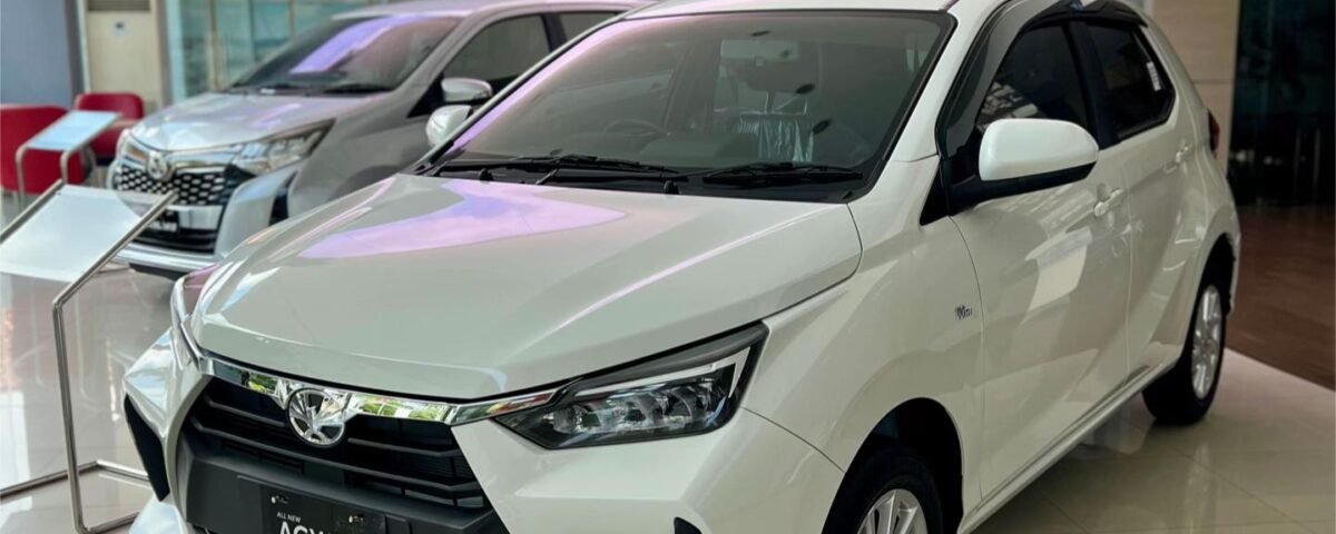 SaveTikTokto_7494885108328025399_1 - Dyantransport White compact SUV on display in a bright car showroom, front grille and badge visible (Agya model)