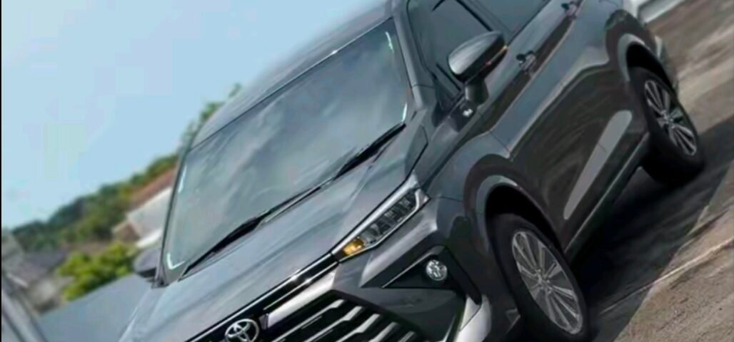 Gray SUV photographed from the front-left angle on a paved outdoor area under a blue sky.