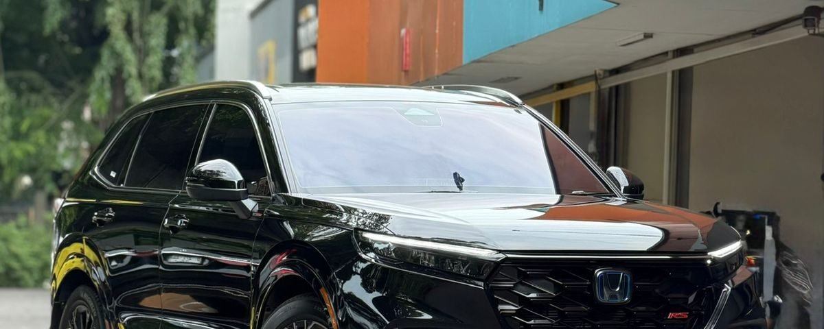 SaveTikTokto_7610825838082280724_1 - Dyantransport Black Honda SUV with glossy finish and large alloy wheels parked beside a colorful orange and teal building.