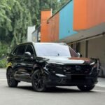 SaveTikTokto_7610825838082280724_1 - Dyantransport Black Honda SUV with glossy finish and large alloy wheels parked beside a colorful orange and teal building.