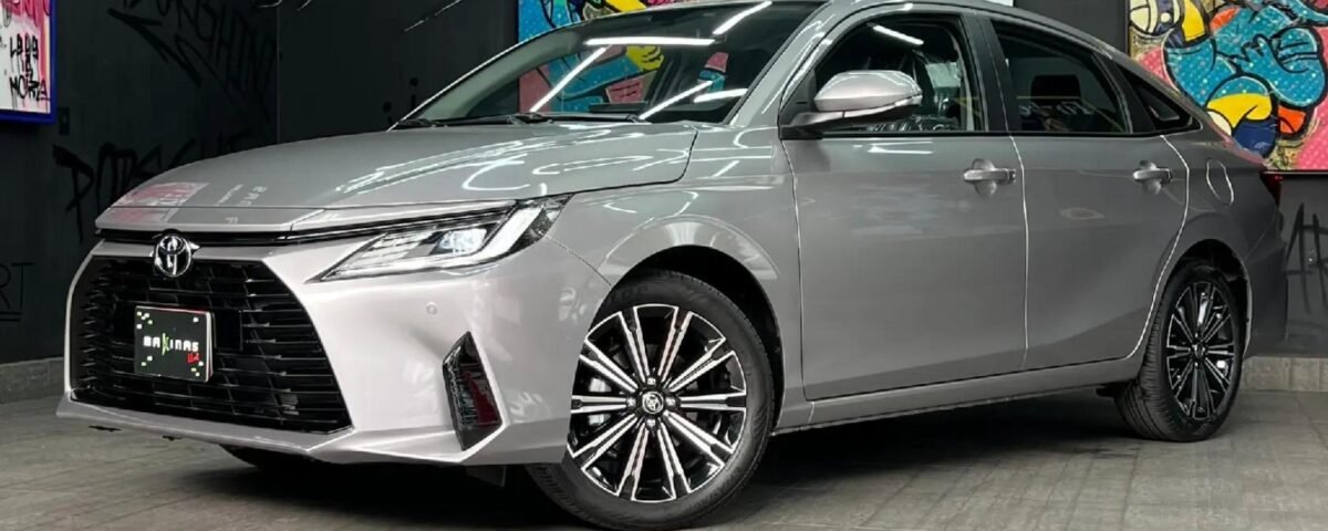 SaveTikTokto_7627230220768087304_3 - Dyantransport Grey sedan displayed indoors in a modern showroom, with graffiti artwork on black walls and bright linear light fixtures above.