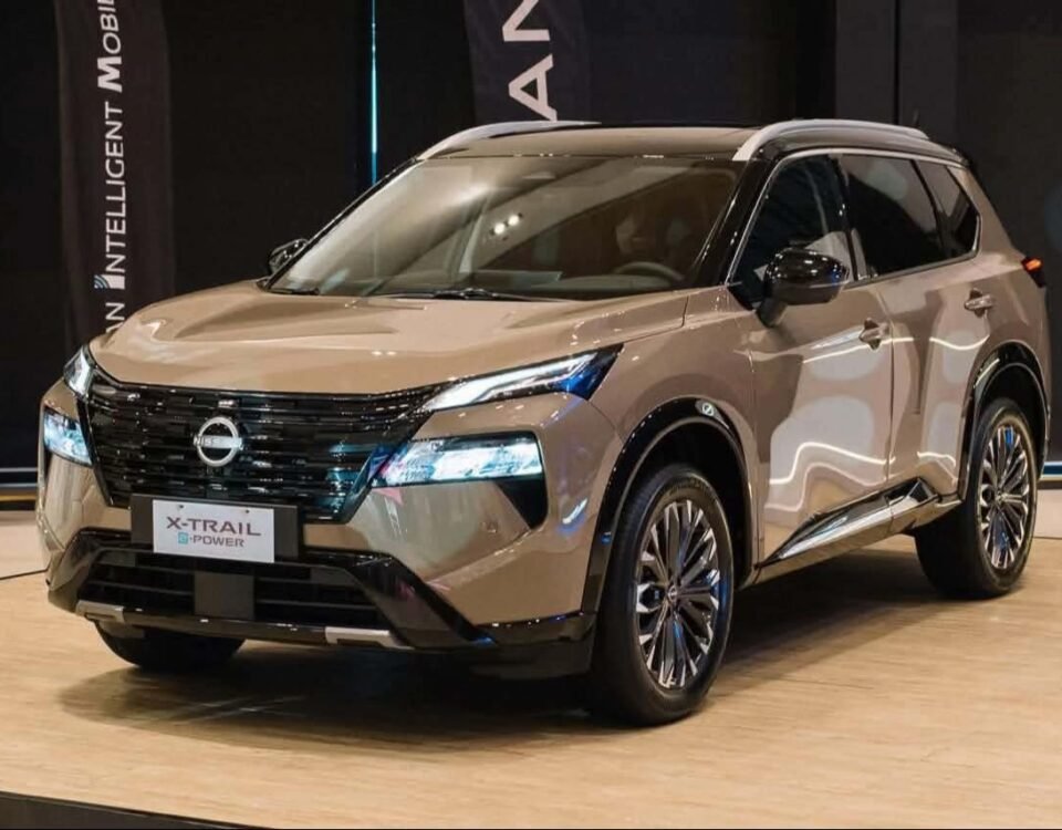 Silver Nissan X-Trail SUV on a showroom floor, facing left, with blue LED headlights and a bold front grille.