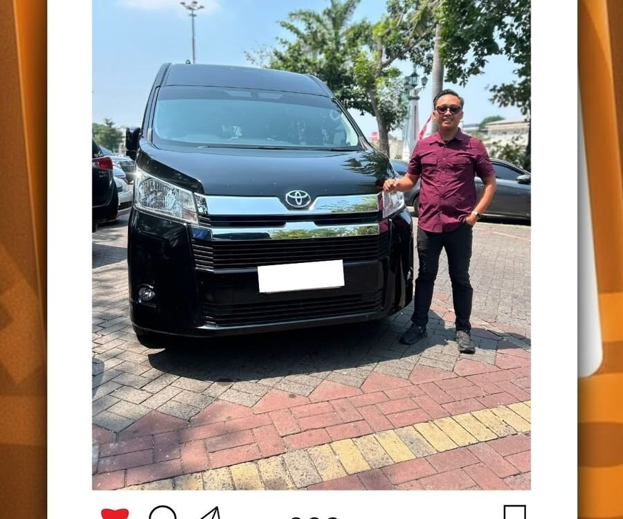 WhatsApp Image 2026-08-20 at 121706 - Dyantransport Man standing beside a black Toyota van in a parking lot; pickup service post for Semarang.
