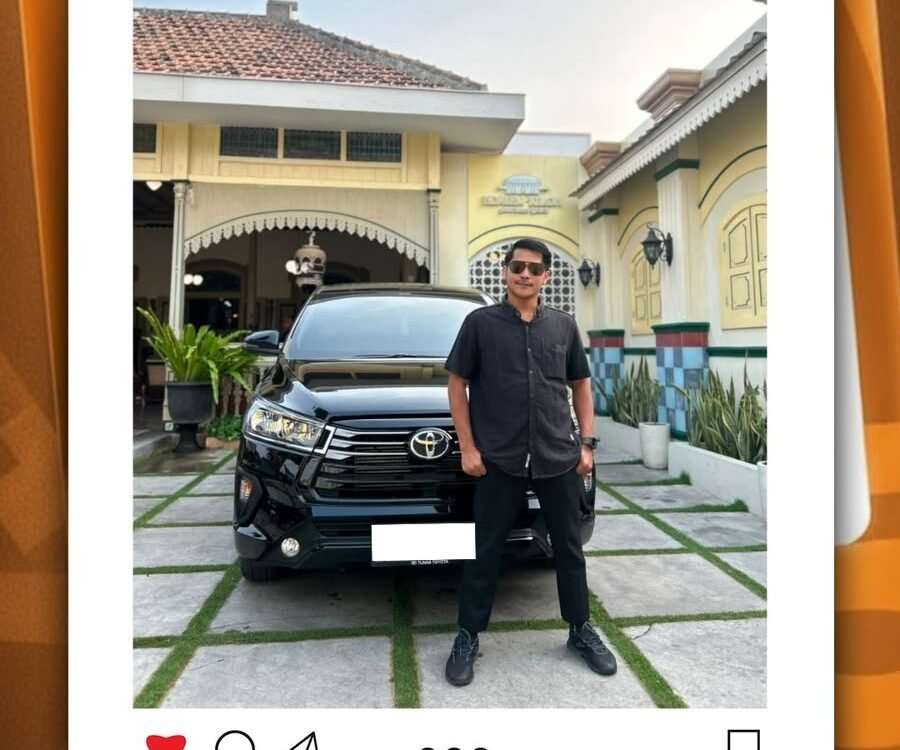 Man in dark shirt and sunglasses stands beside a black Toyota SUV in a driveway in front of a yellow house.