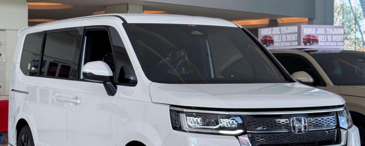 White Honda StepWGN minivan on a glossy showroom floor with a red carpet and large glass windows in the background.