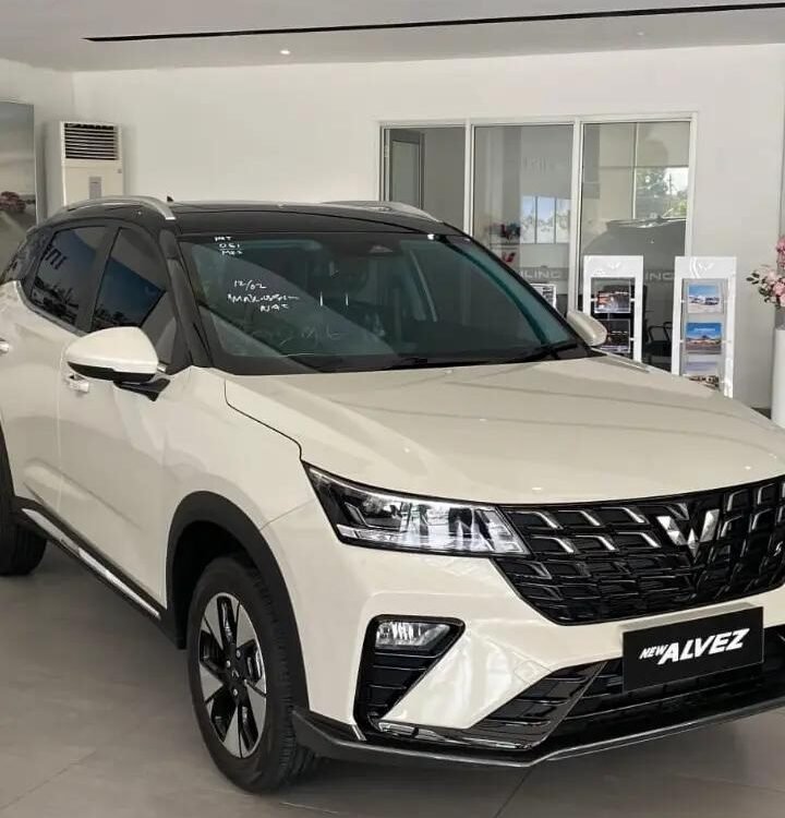 White SUV on showroom floor with black grille and modern headlights, labeled NEW AZVEZ (Alvez) on the front plate, bright dealership setting.