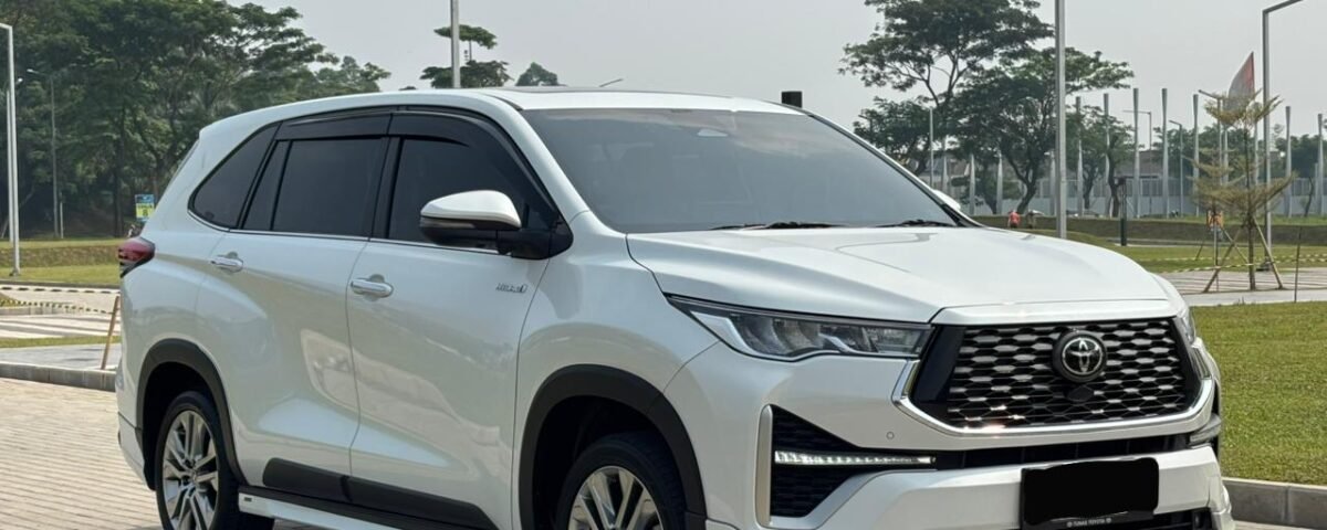 White Toyota SUV parked on a paved area, front three-quarter view showing large grille and sleek headlights.