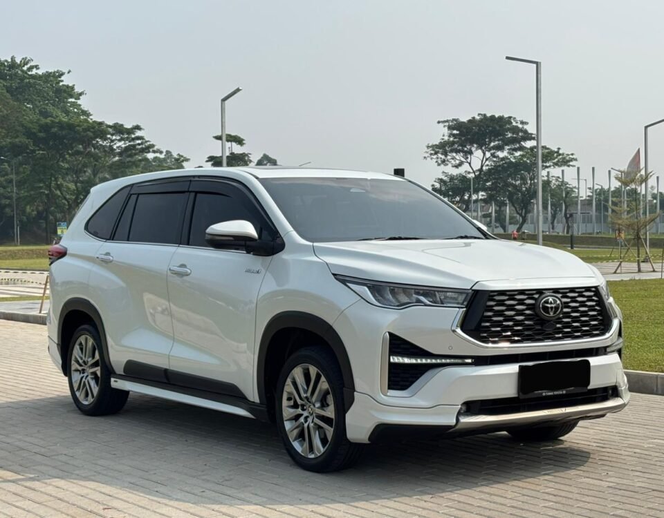 White Toyota SUV parked on a paved area, front three-quarter view showing large grille and sleek headlights.