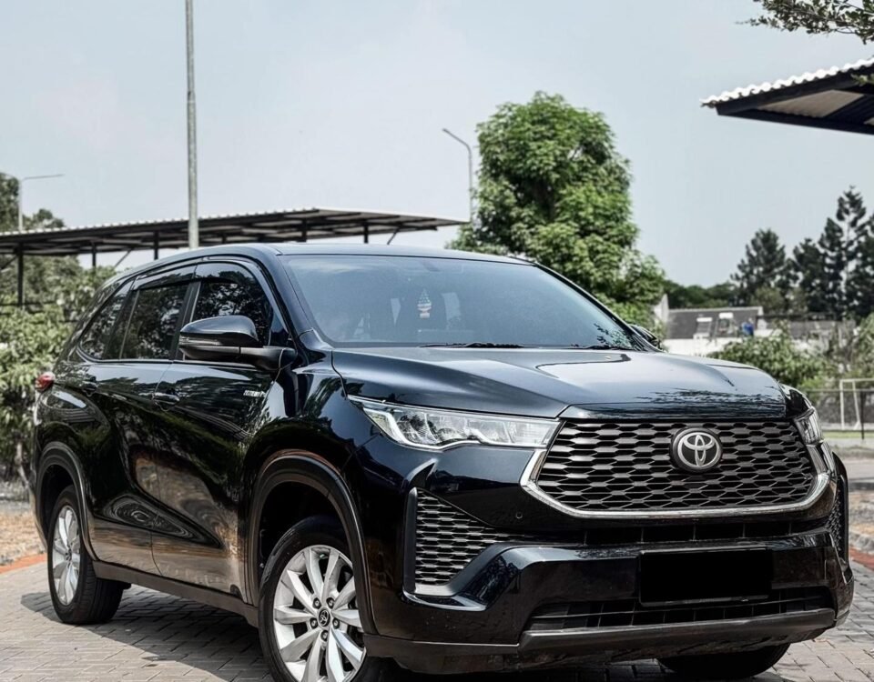 Black Toyota SUV parked on a brick-paved lot, showing the front grille and headlights with a blue sky backdrop.