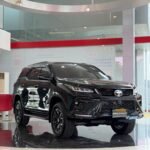 snaptik-app-7673778446996098322-slide-1 - Dyantransport Black Toyota Fortuner on showroom floor, glossy finish, front grille visible, reflections on polished tiles behind glass walls